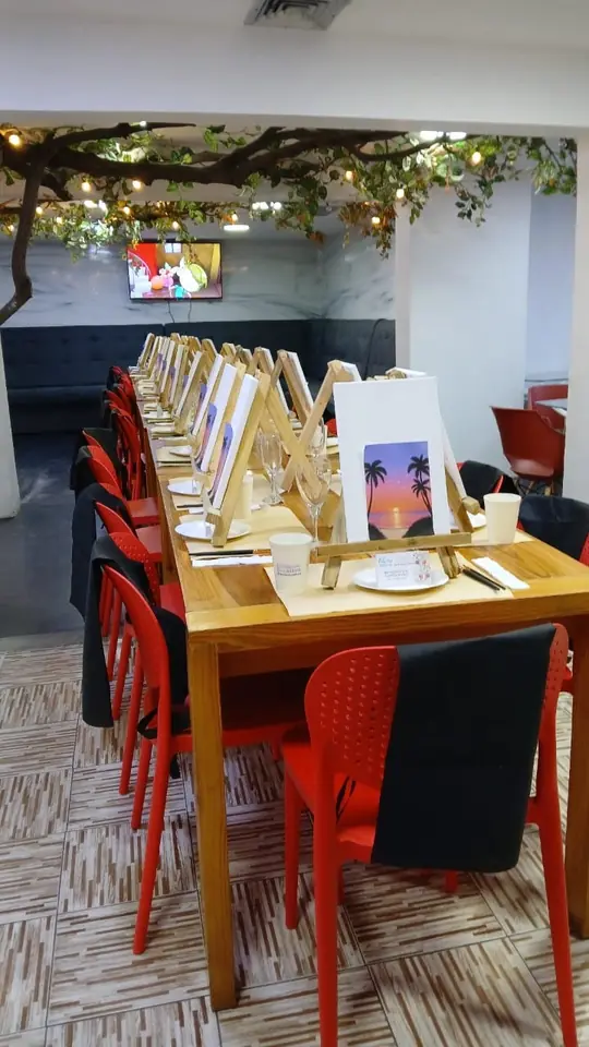 Mesa larga preparada con lienzos y caballetes para un taller