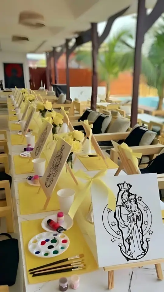 Mesa decorada con lienzos para pintar y rosas amarillas