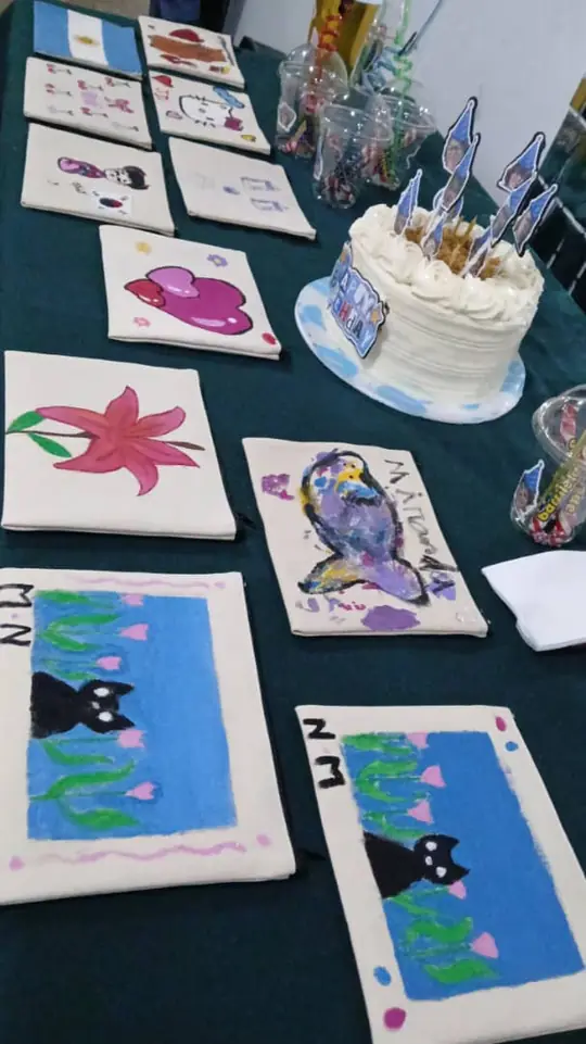 Tote bags pintadas a mano junto a una torta de cumpleaños